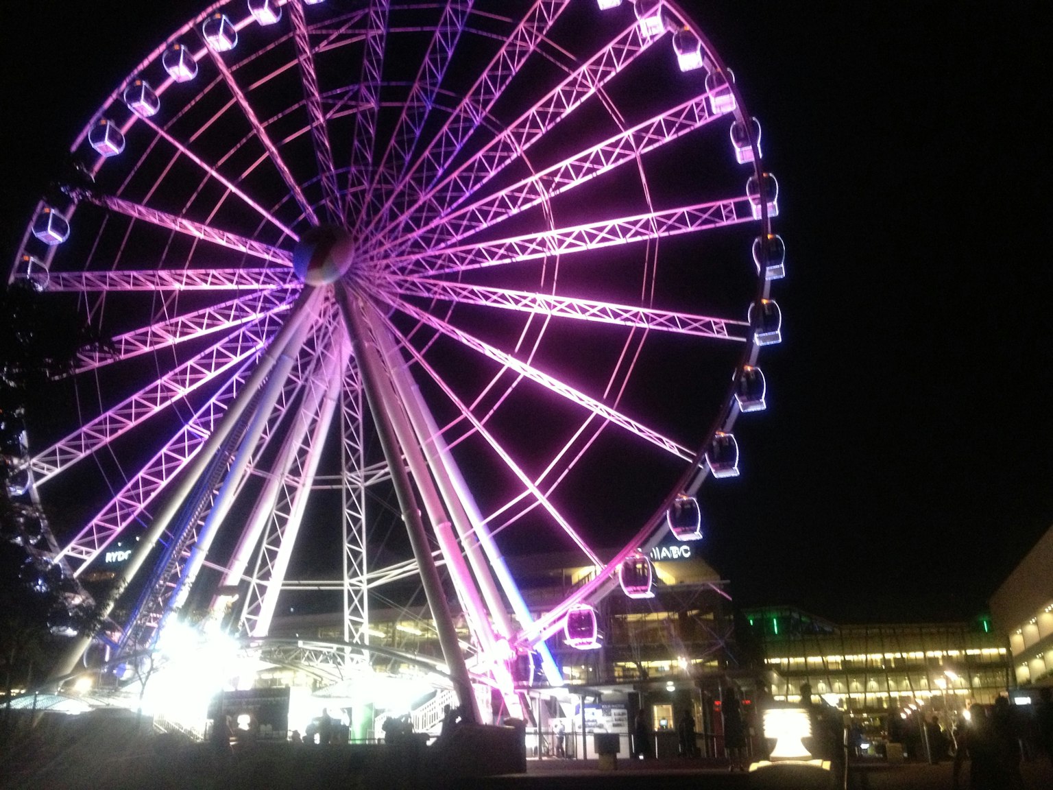 Grande roue illuminée la nuit avec des couleurs vives