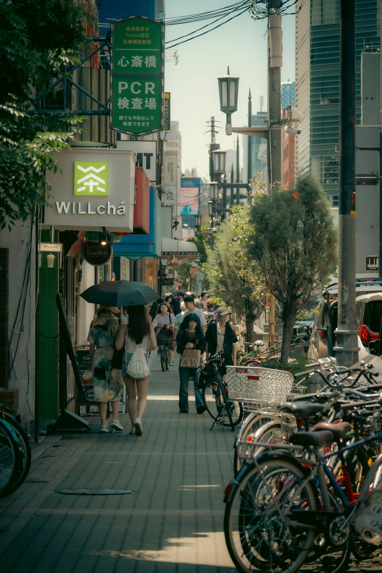 繁忙的街景，人們走動，旁邊停放著自行車