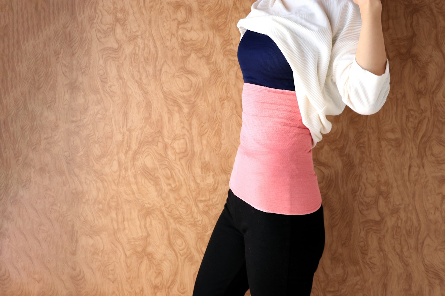 Donna che indossa una fascia rosa in posa contro uno sfondo di legno