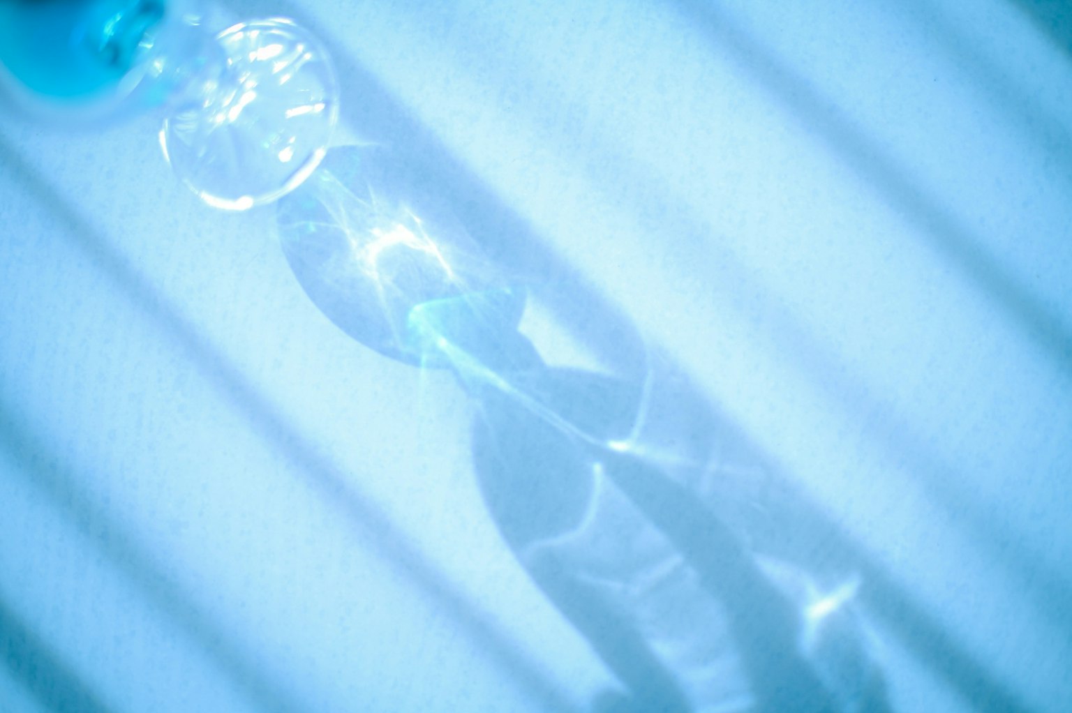 Gotas de agua transparentes reflejando la luz sobre un fondo azul