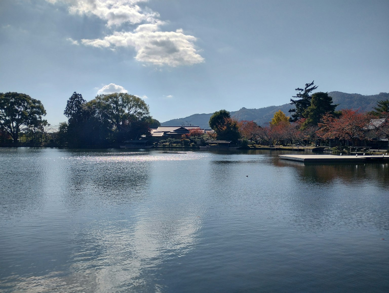 Vista panoramica di un lago che riflette alberi autunnali e montagne