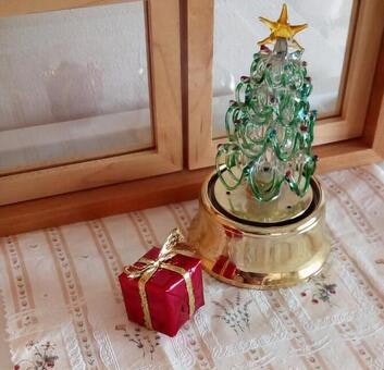 Meja di dalam ruangan dengan hiasan pohon Natal dan kotak hadiah