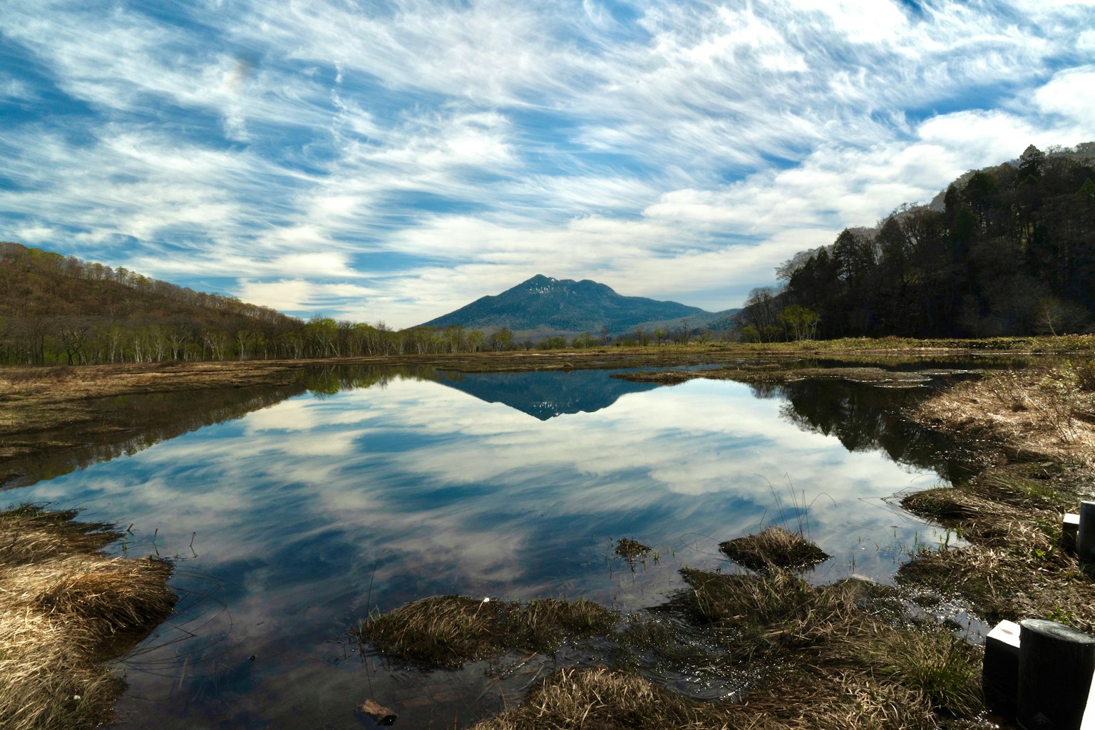 Vista escénica de un lago que refleja el cielo y las montañas