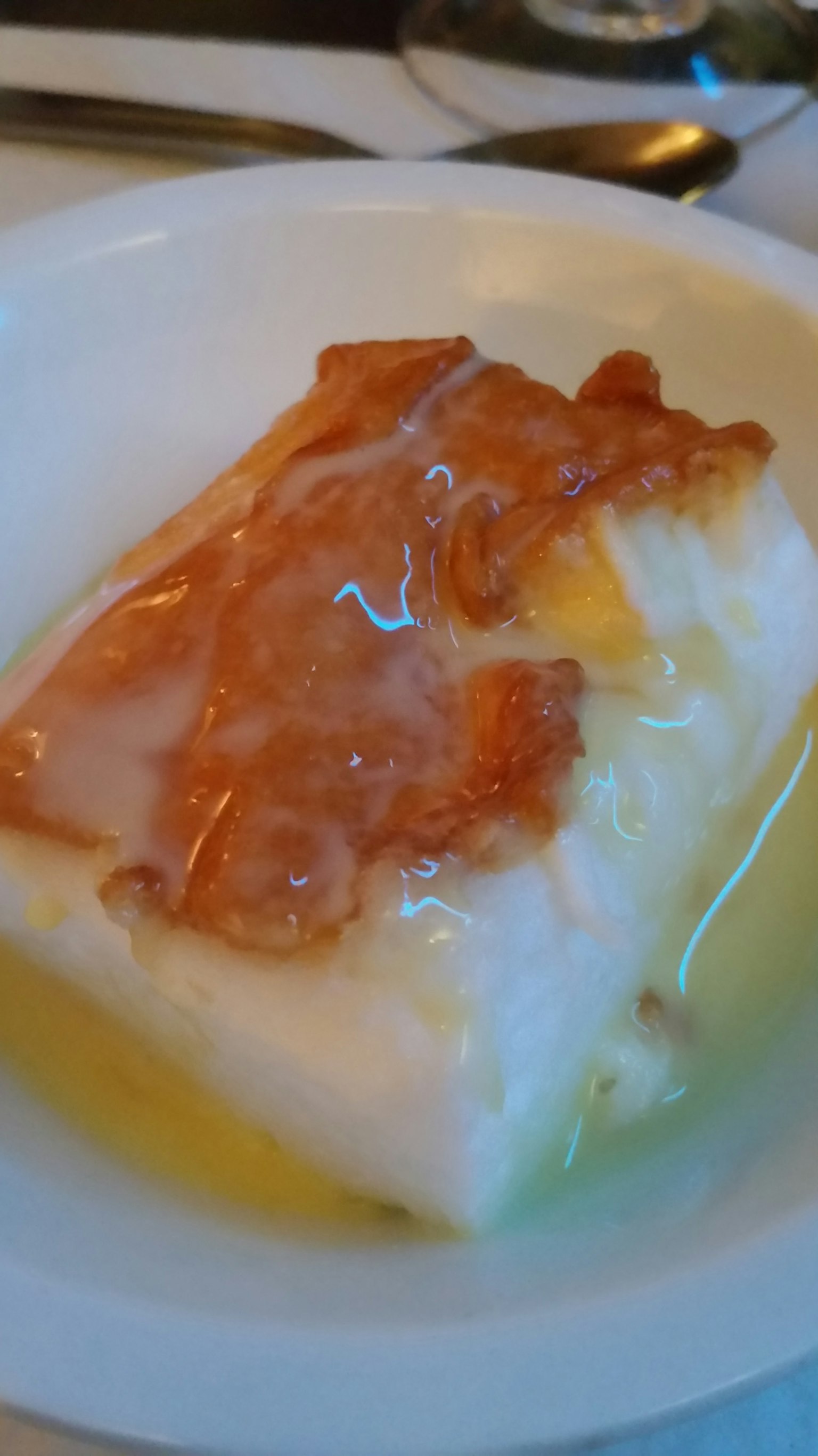 一塊白色魚肉上面覆蓋著淡橙色醬汁