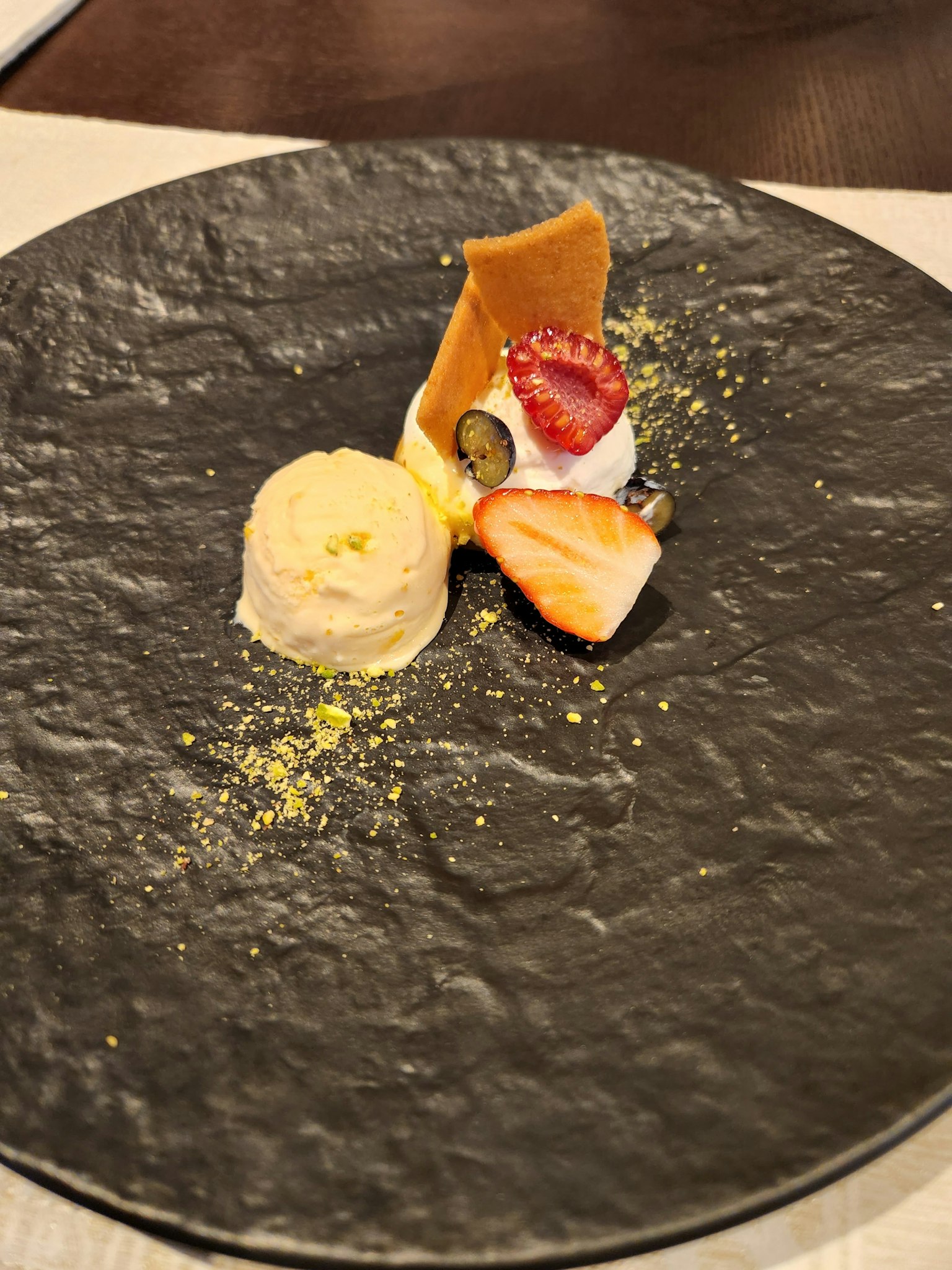 Presentazione artistica di dessert su un piatto nero
