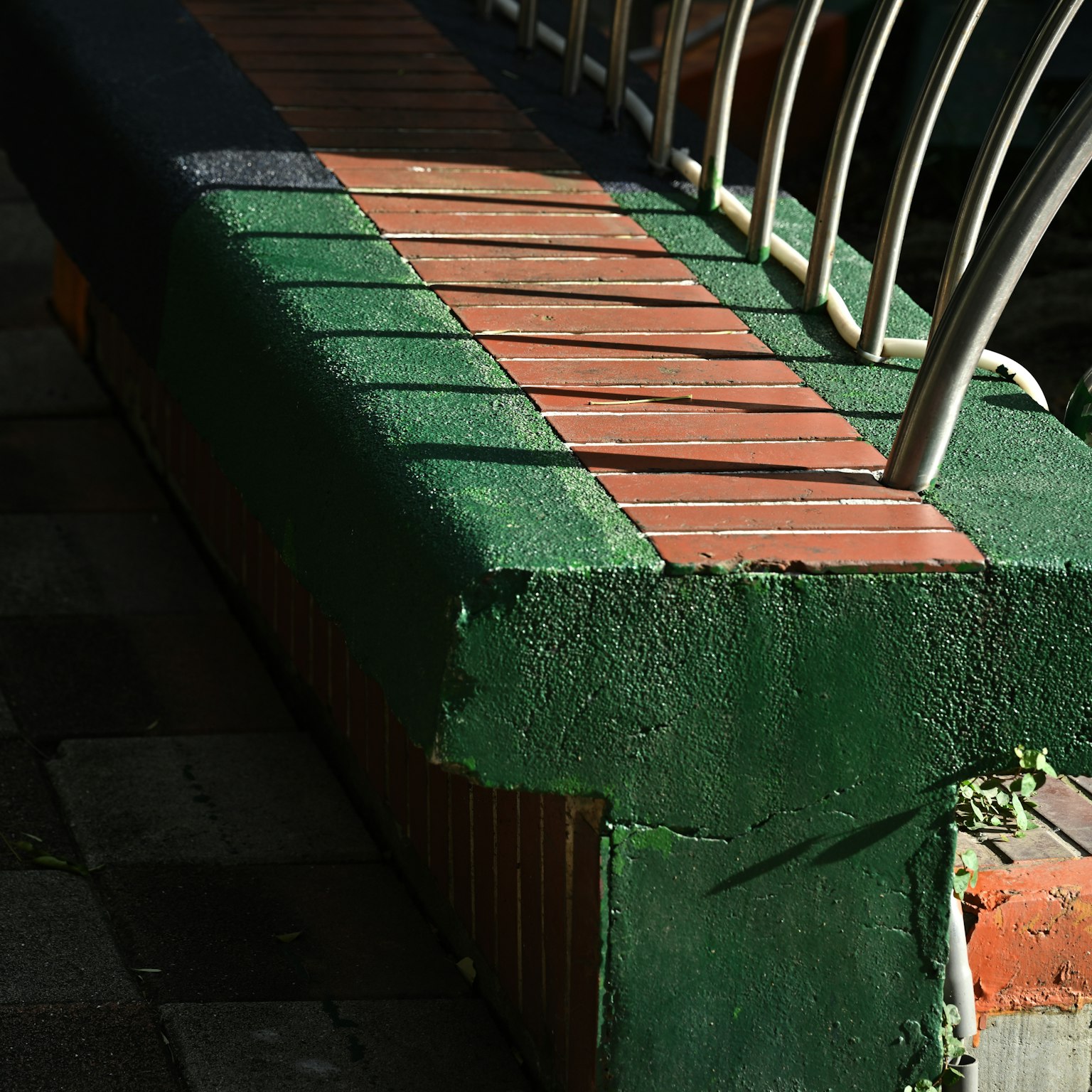 緑と赤のタイルで装飾されたベンチの側面のクローズアップ