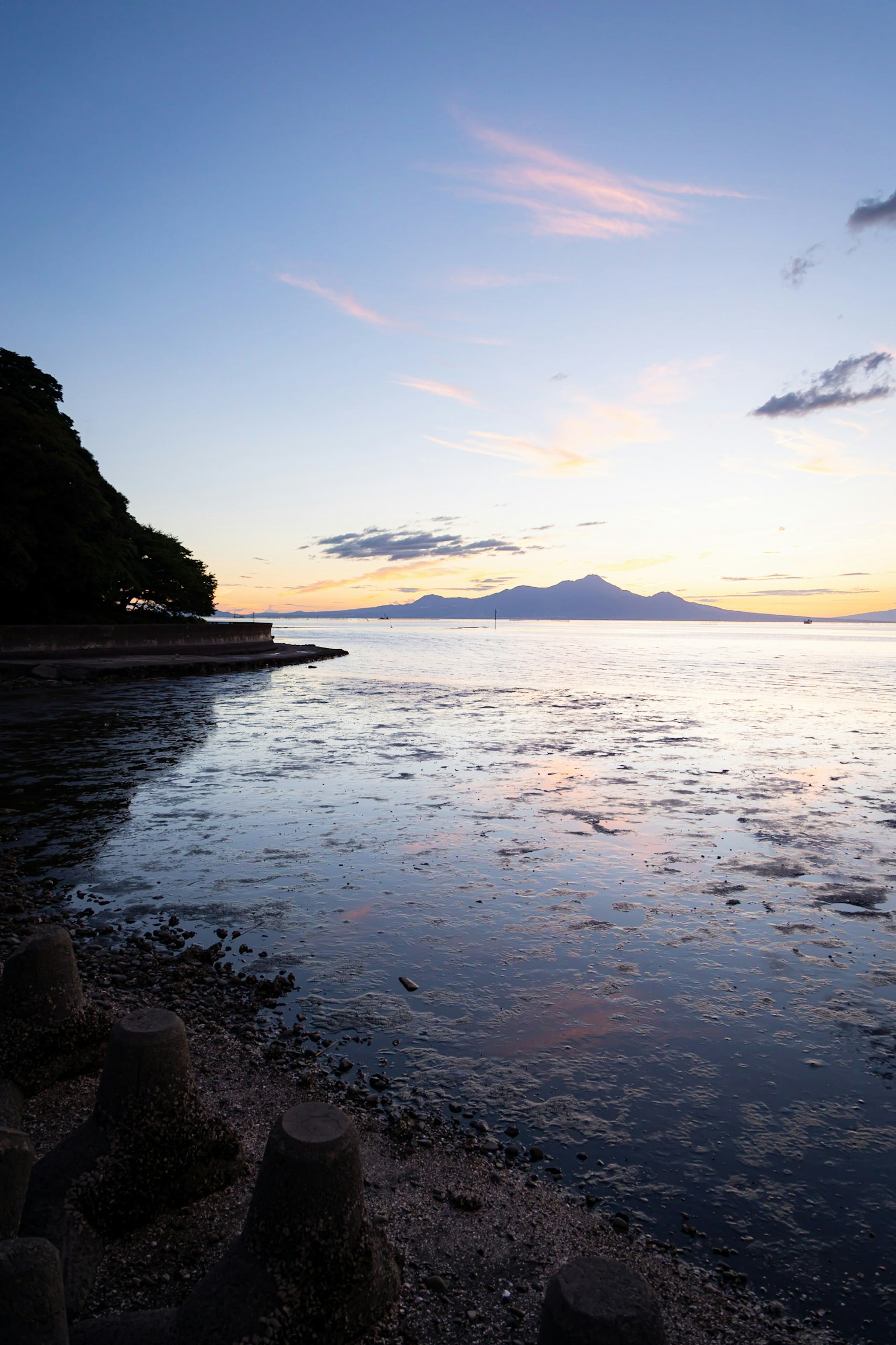 Calm seascape with mountain silhouette at sunset