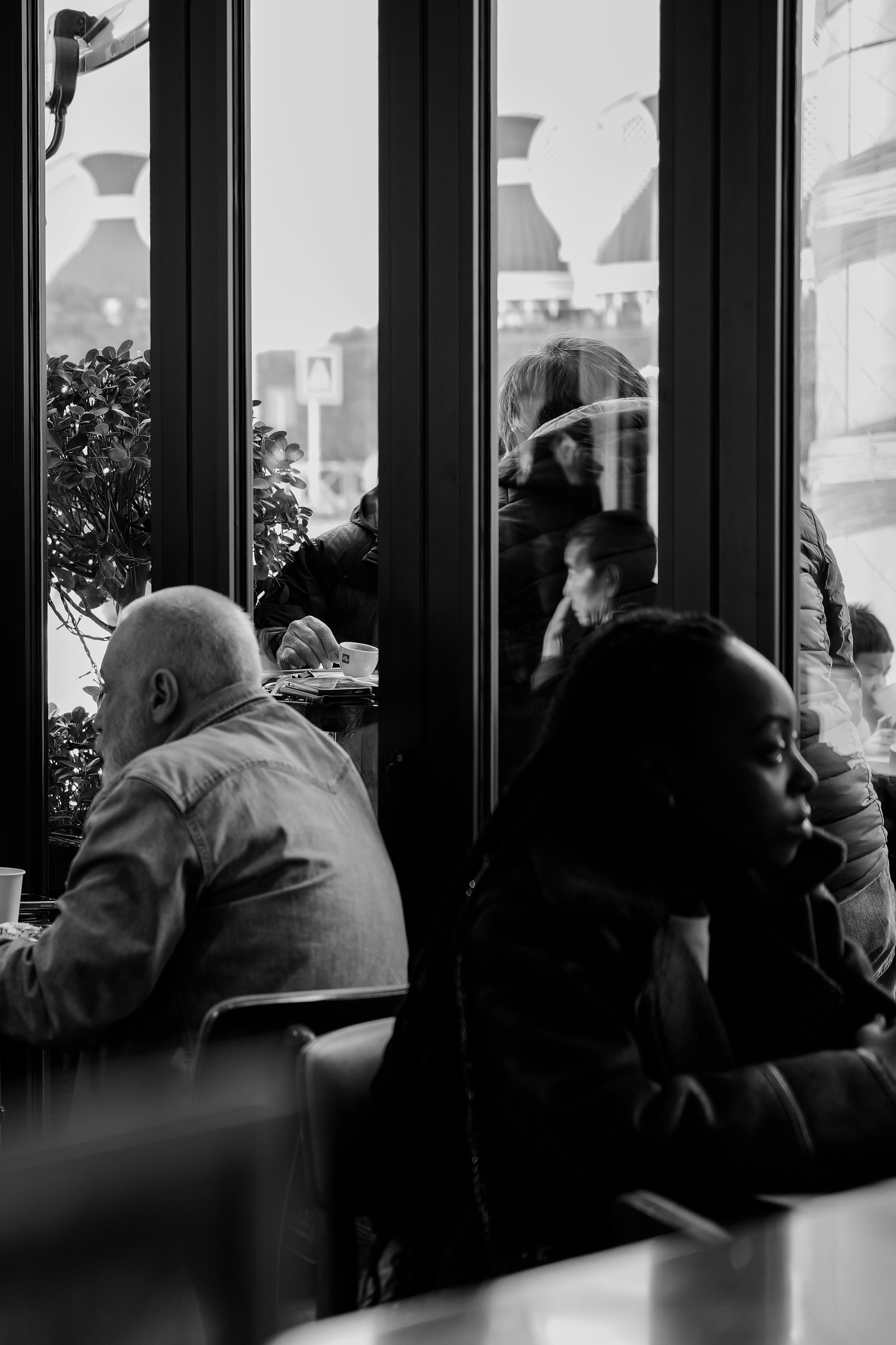 Monochrome scene of people chatting in a cafe by the window