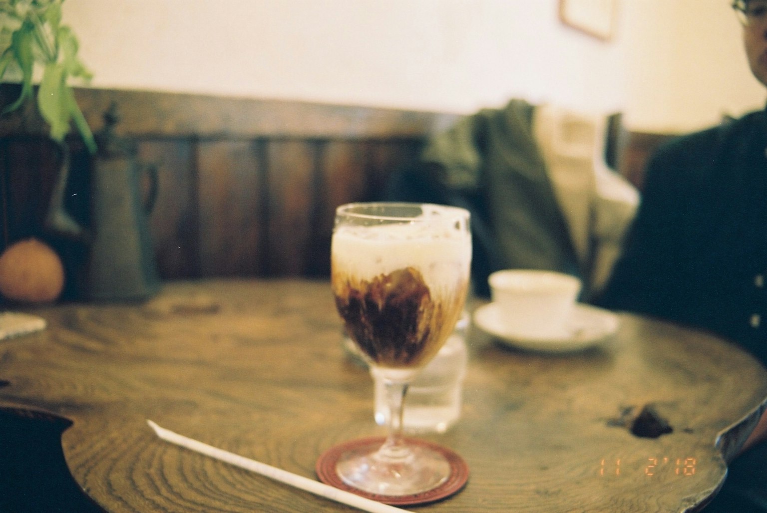 Verre de café glacé sur une table en bois dans un café chaleureux