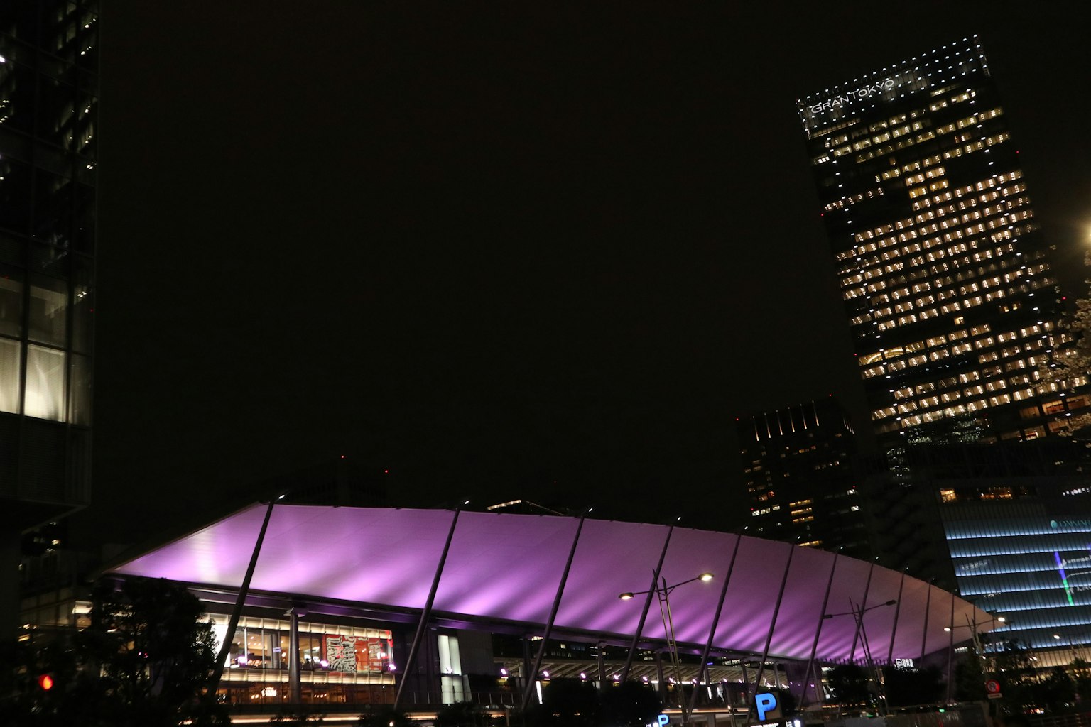 Bâtiment moderne avec un toit violet dans un paysage urbain nocturne