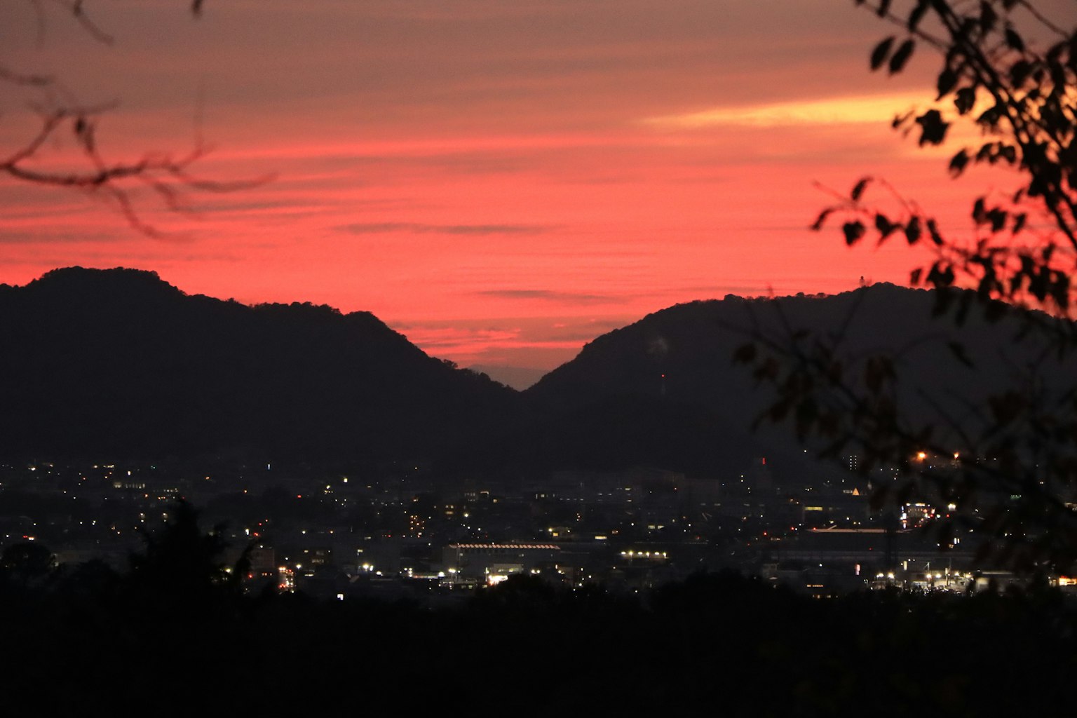 夕焼けの空と山々のシルエットが見える風景