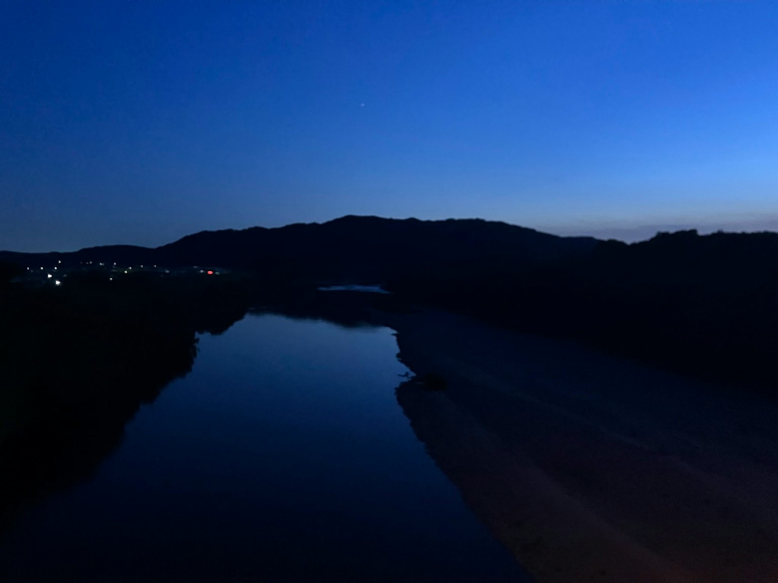 夜晚的風景，有一條黑暗的河流和山脈