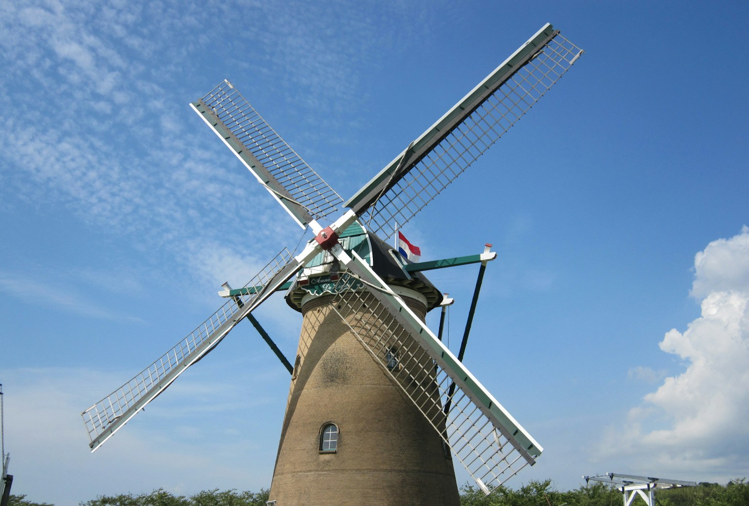 Kincir angin berputar di bawah langit biru