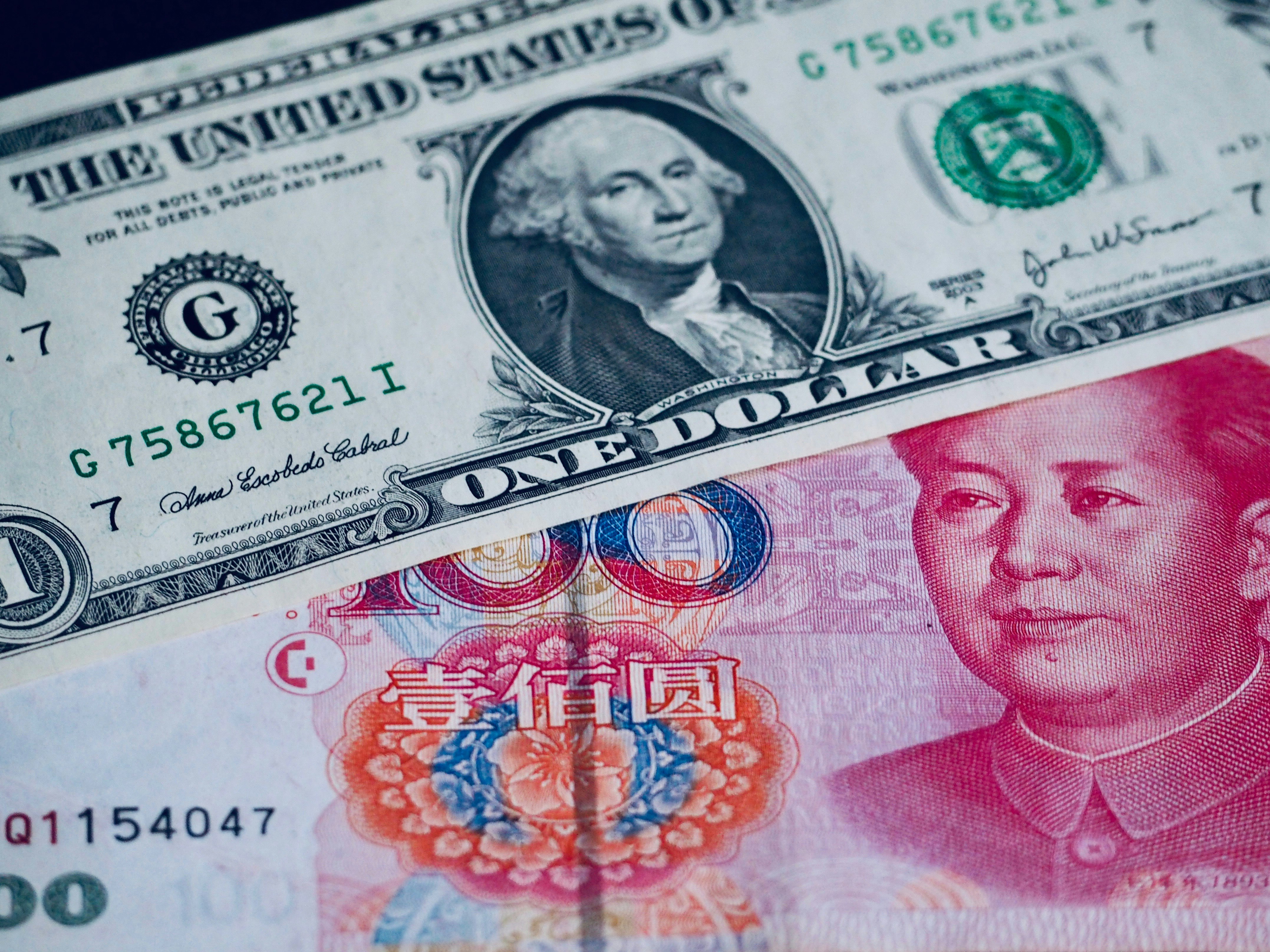 close-up tumpukan uang kertas dolar AS dan mata uang Tiongkok