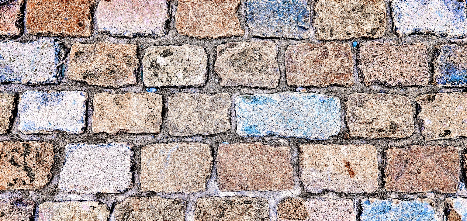 Close-up of a stone wall featuring a variety of colored bricks