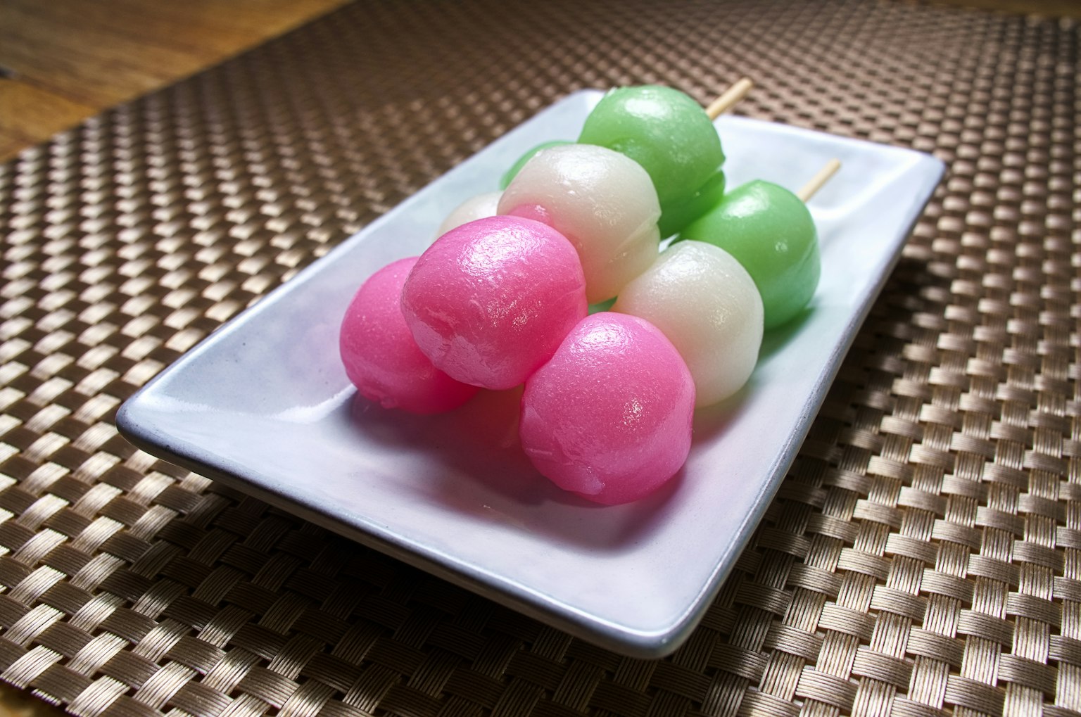 Brochettes de dango coloré sur une assiette blanche
