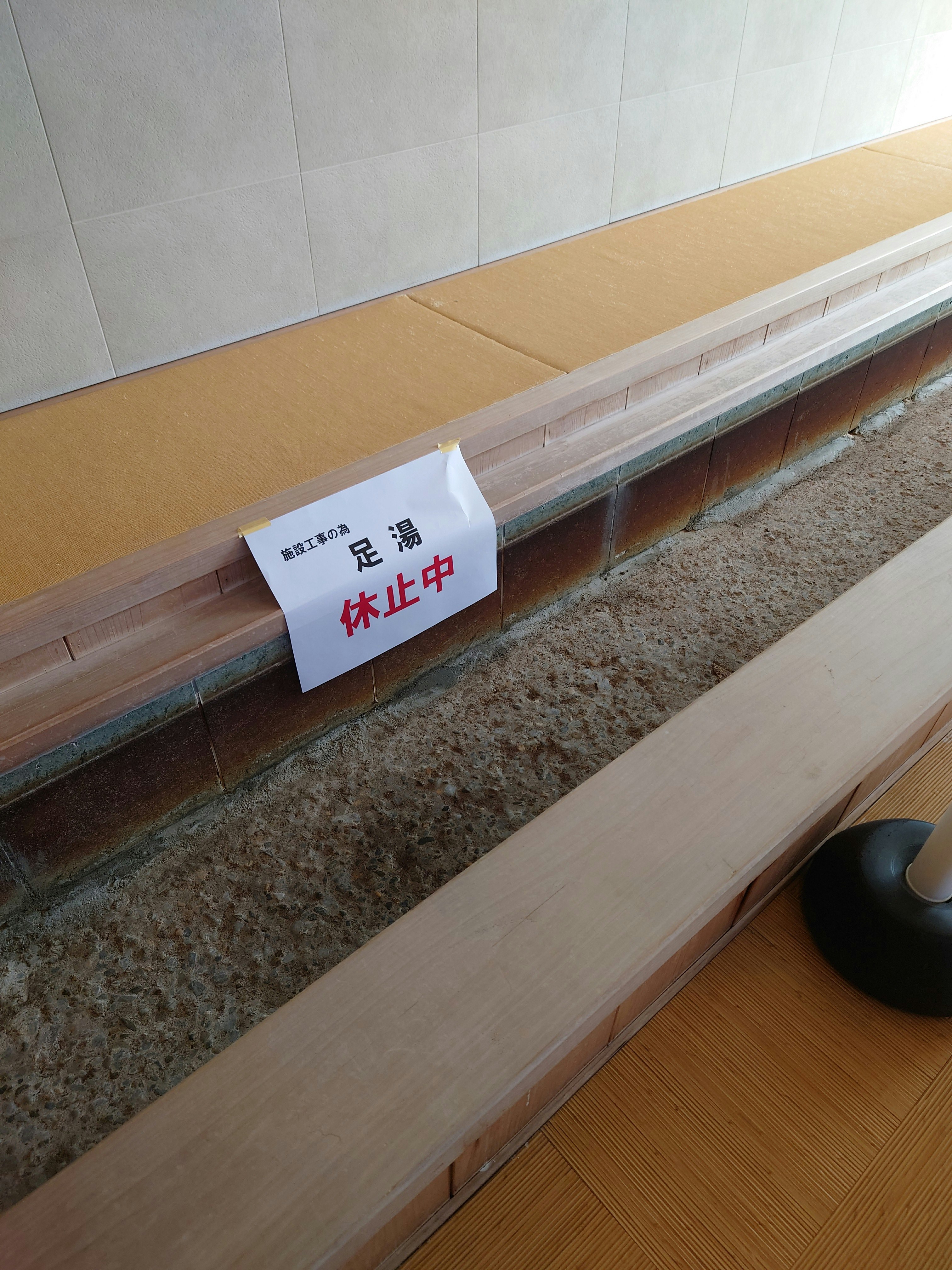 床下に敷かれた砂利と「足止め中」の注意札のある通路