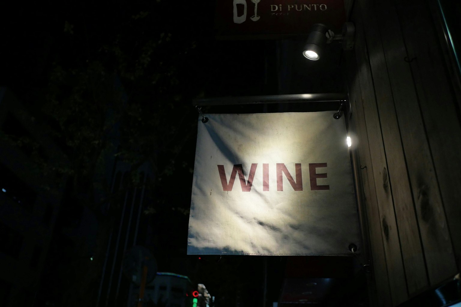 Cartel nocturno con la palabra 'WINE' en letras rojas en negrita