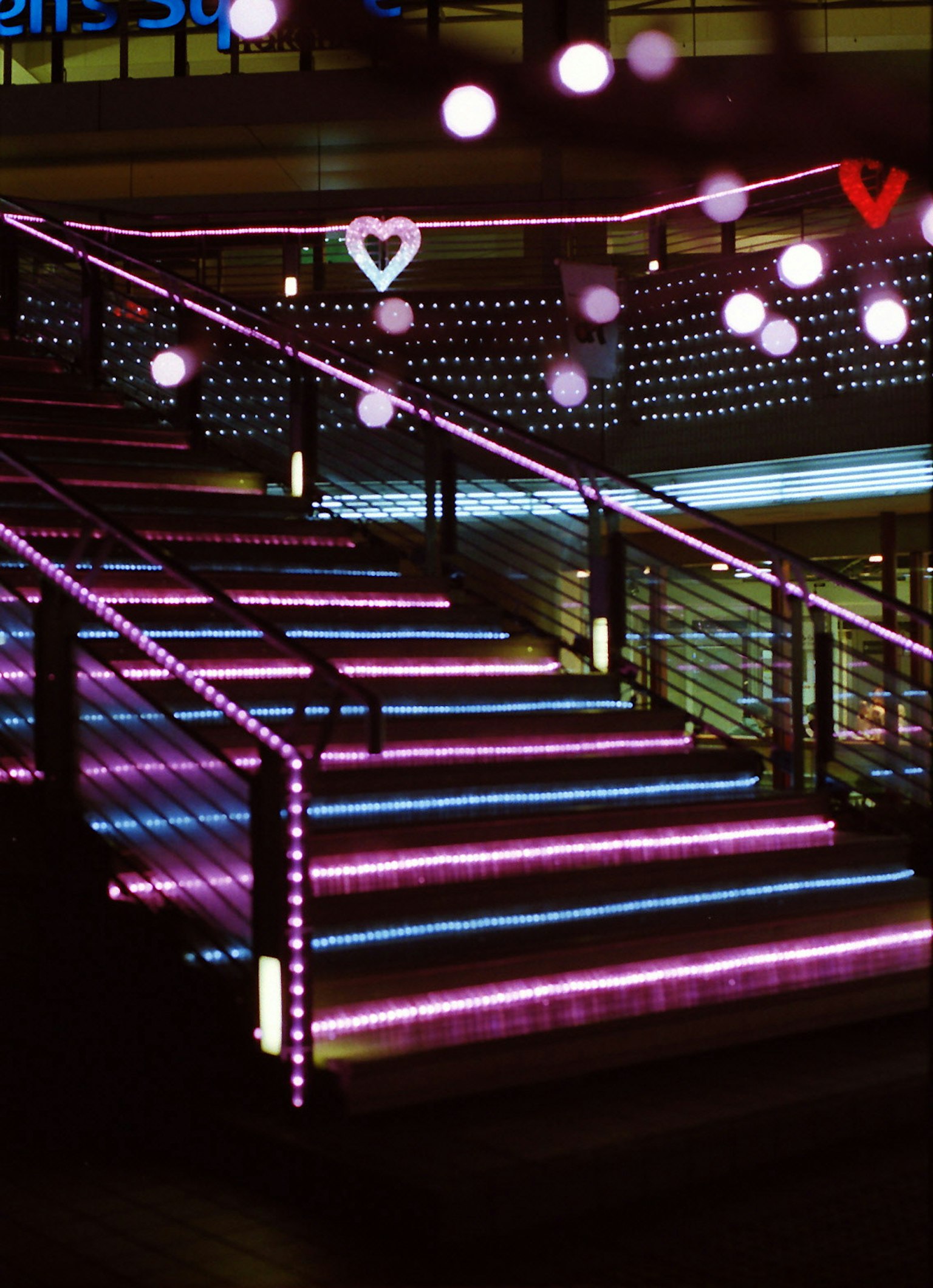 ภาพของบันไดที่ประดับด้วยไฟ LED สีชมพูสดใส