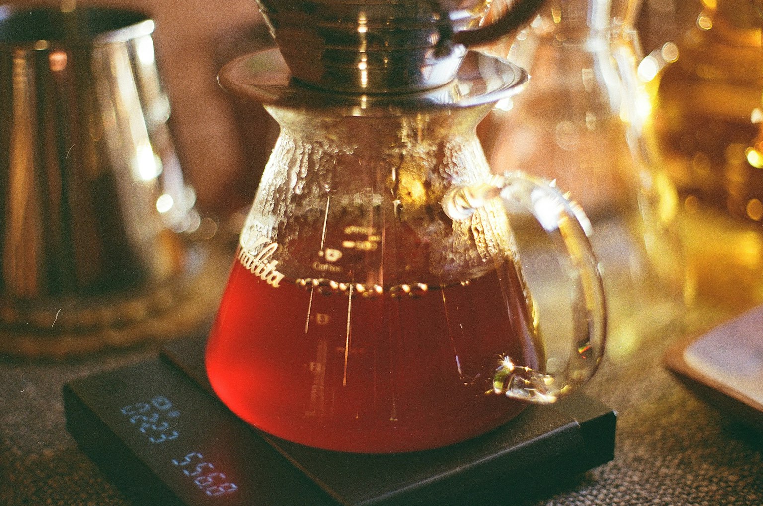 Una tetera transparente llena de té infusionado sobre una encimera