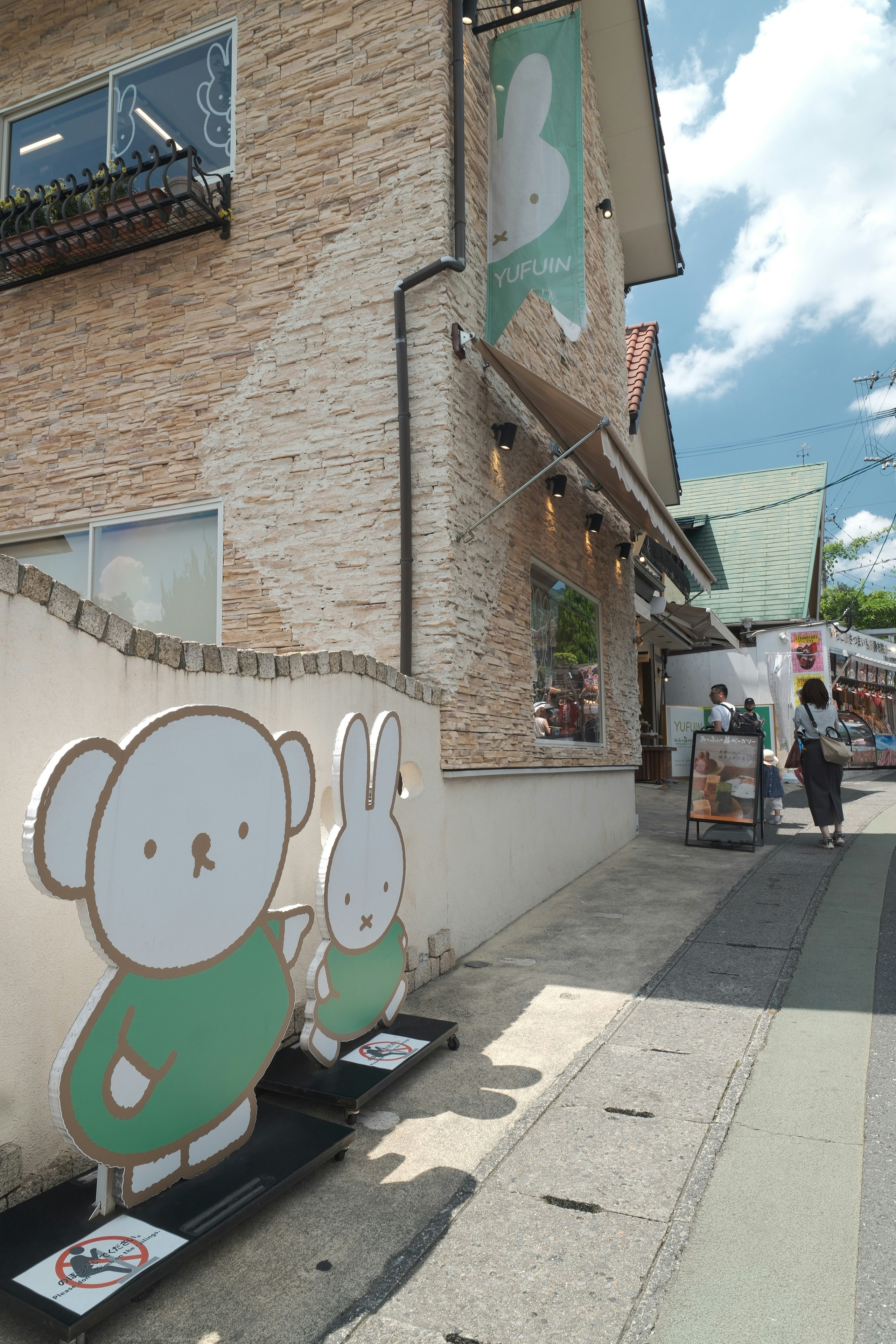由布市・湯布院の路地に並ぶ店舗前の看板と壁面
