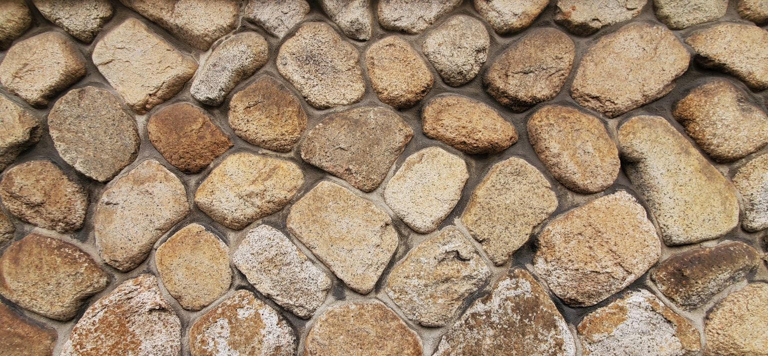 Textured wall made of various colored stones