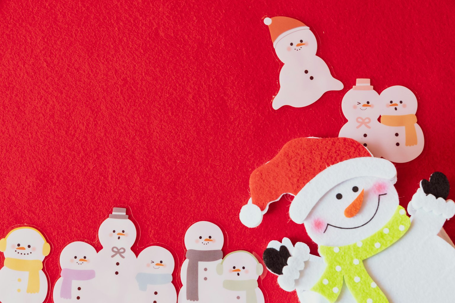 Pupazzi di neve colorati con un cappello di Babbo Natale su uno sfondo rosso