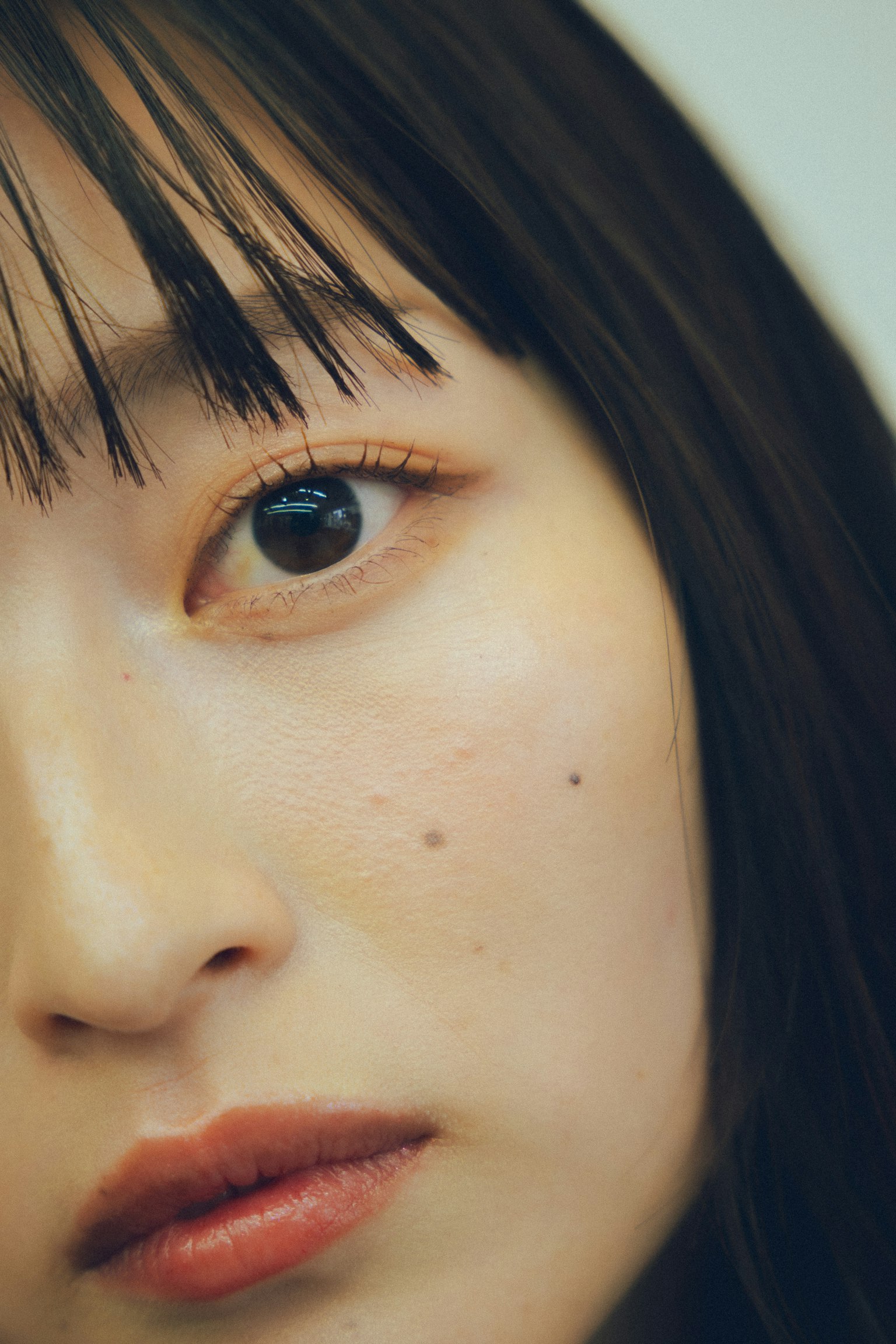 Primo piano del volto di una donna con capelli neri che mostra bellezza naturale ed espressione delicata