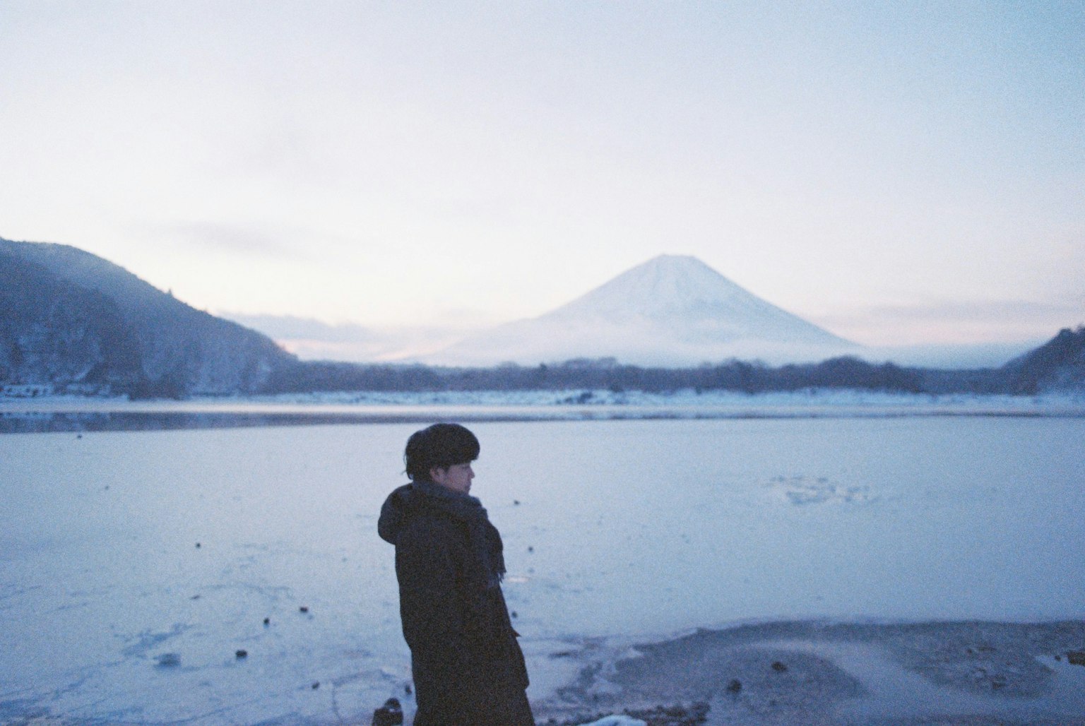雪覆蓋的富士山背景下站著的人物輪廓