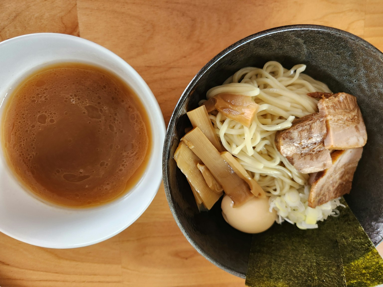 Bowl of ramen with dipping sauce and toppings