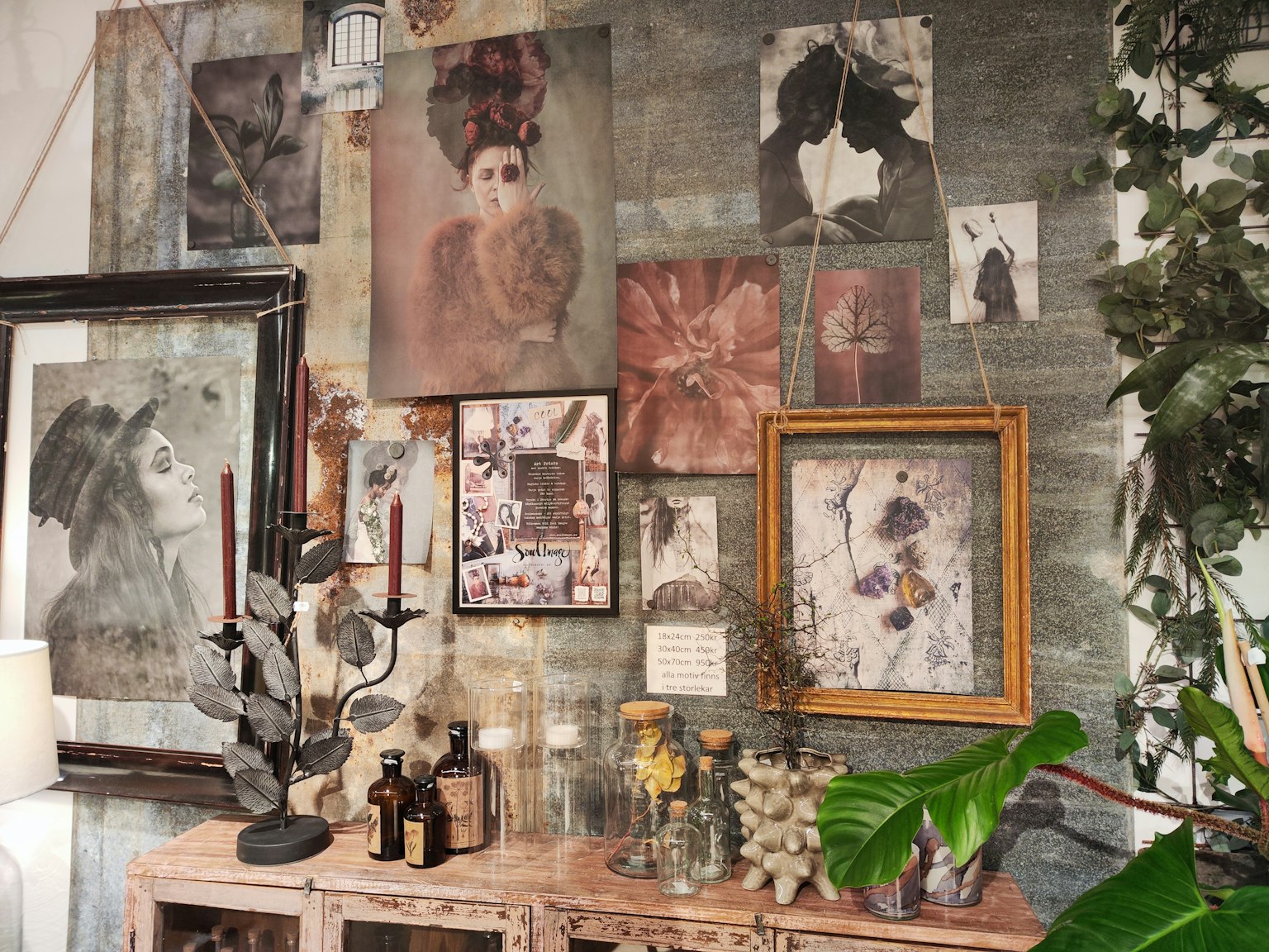 Una sezione di una stanza con un muro d'arte che presenta varie foto e dipinti accanto a mobili decorativi