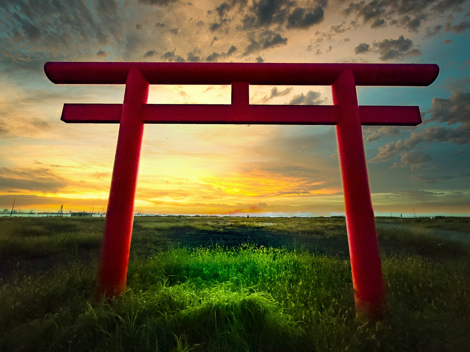 紅色鳥居在夕陽和綠色草地前