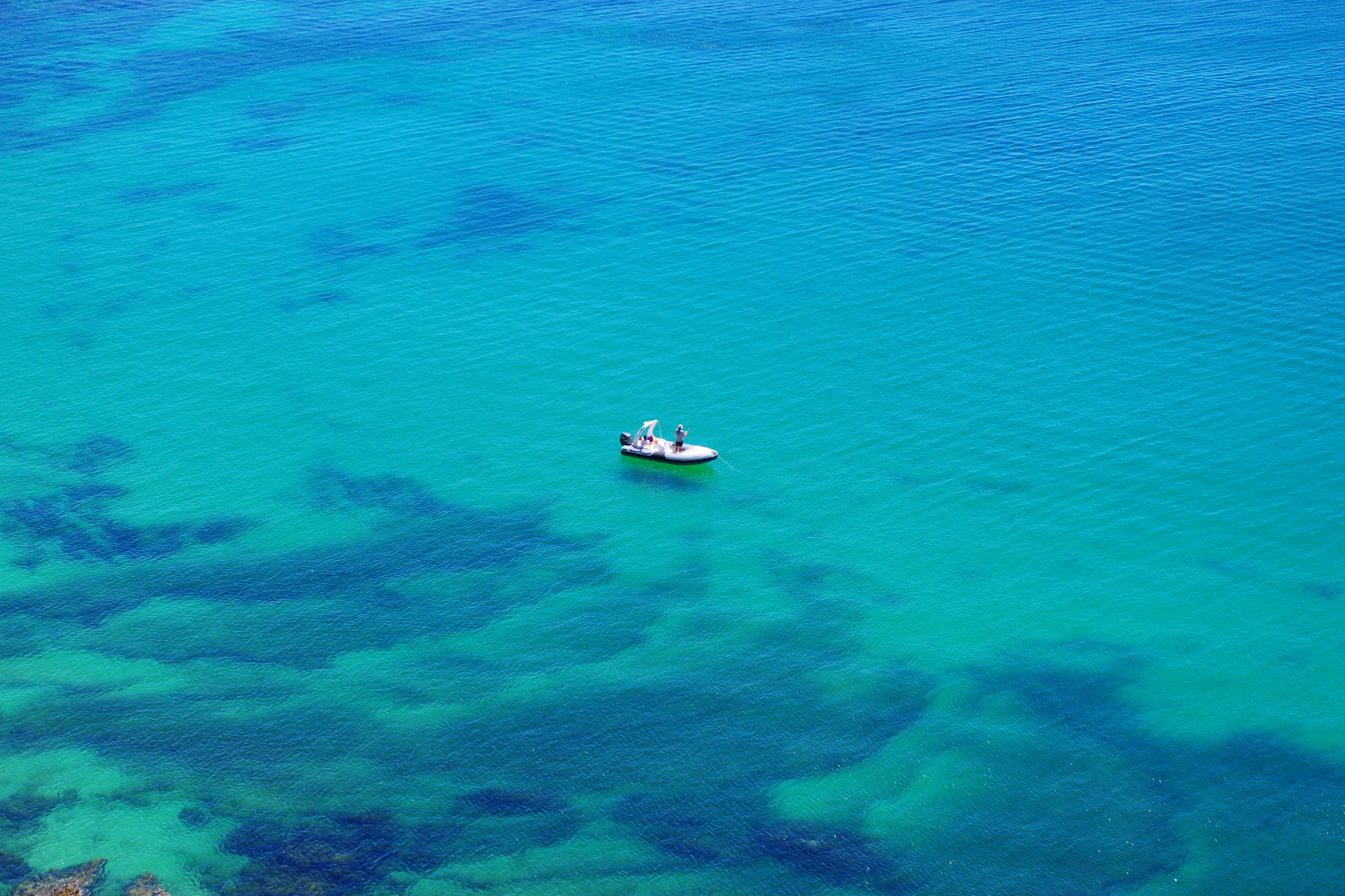 澄んだ青い海に浮かぶ小さなボート