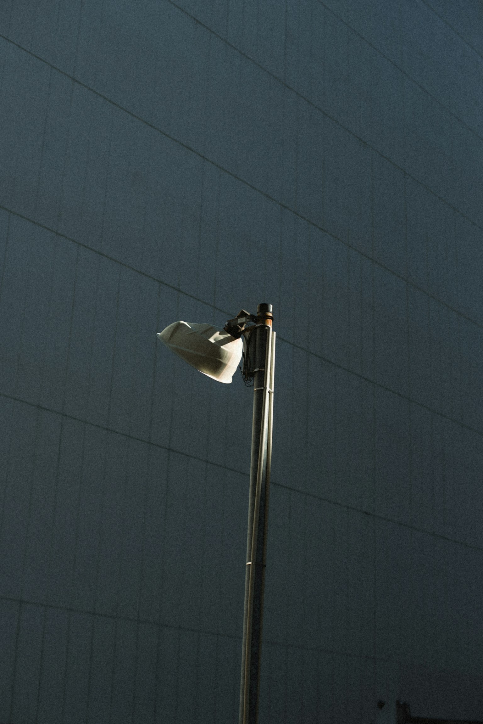 Una farola blanca se alza contra un fondo oscuro