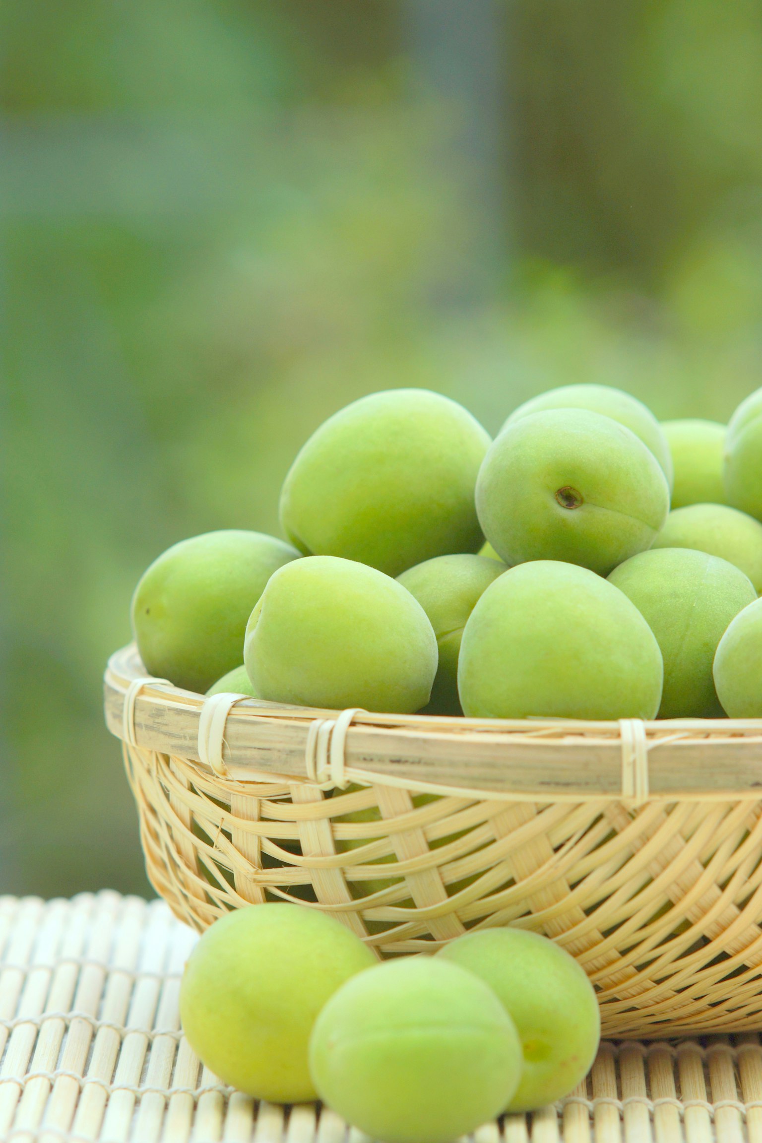 Fresh green plums in a wicker basket