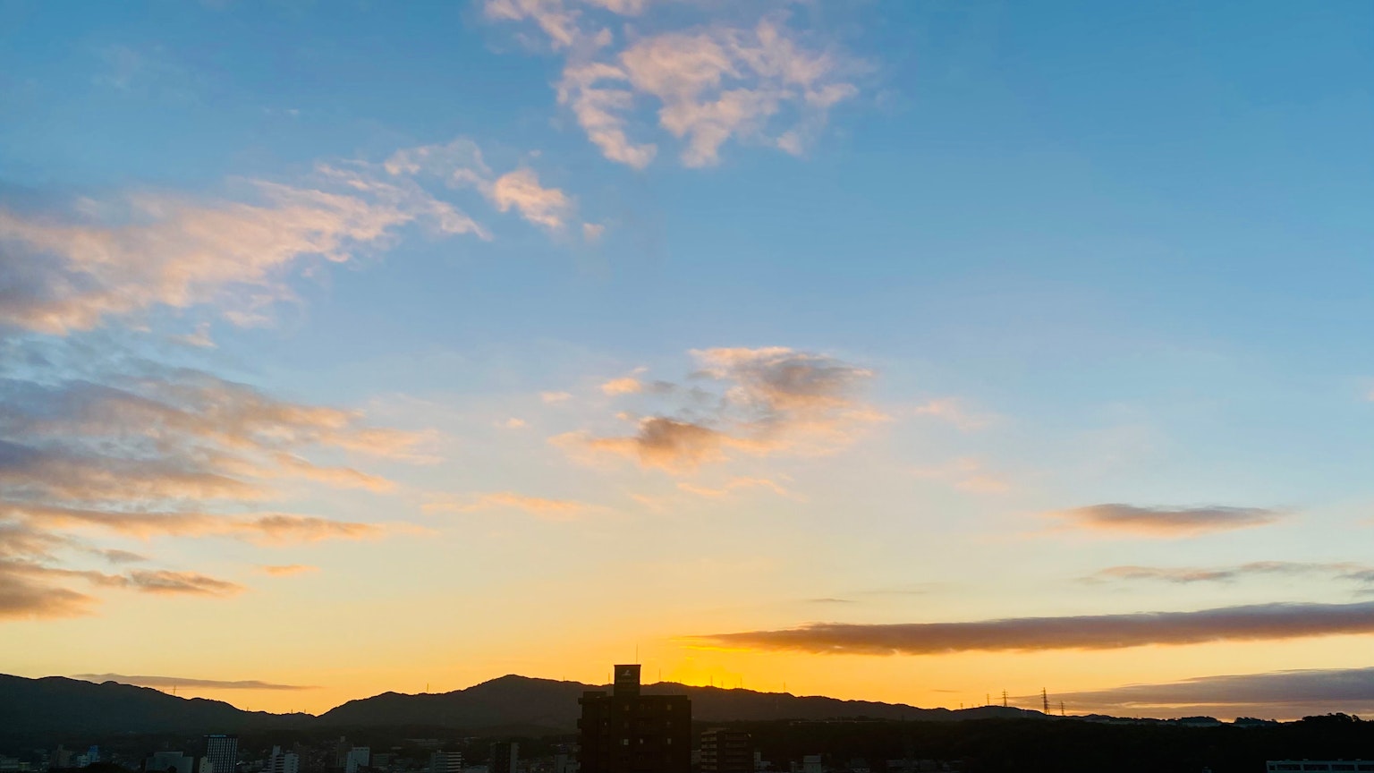 Malersicher Blick auf den Sonnenuntergangshimmel mit Silhouetten von Bergen