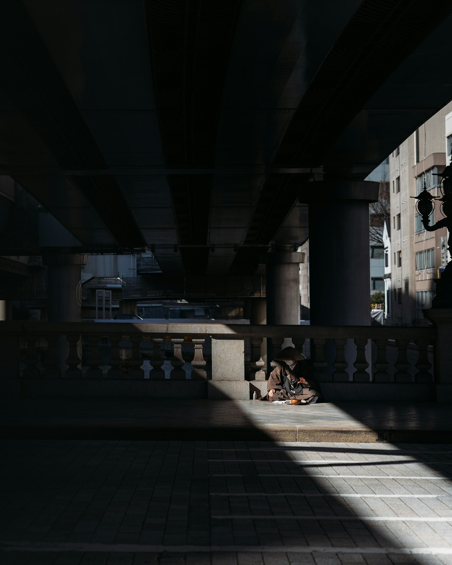 Une scène frappante sous un pont mettant en valeur le contraste entre la lumière et l'ombre