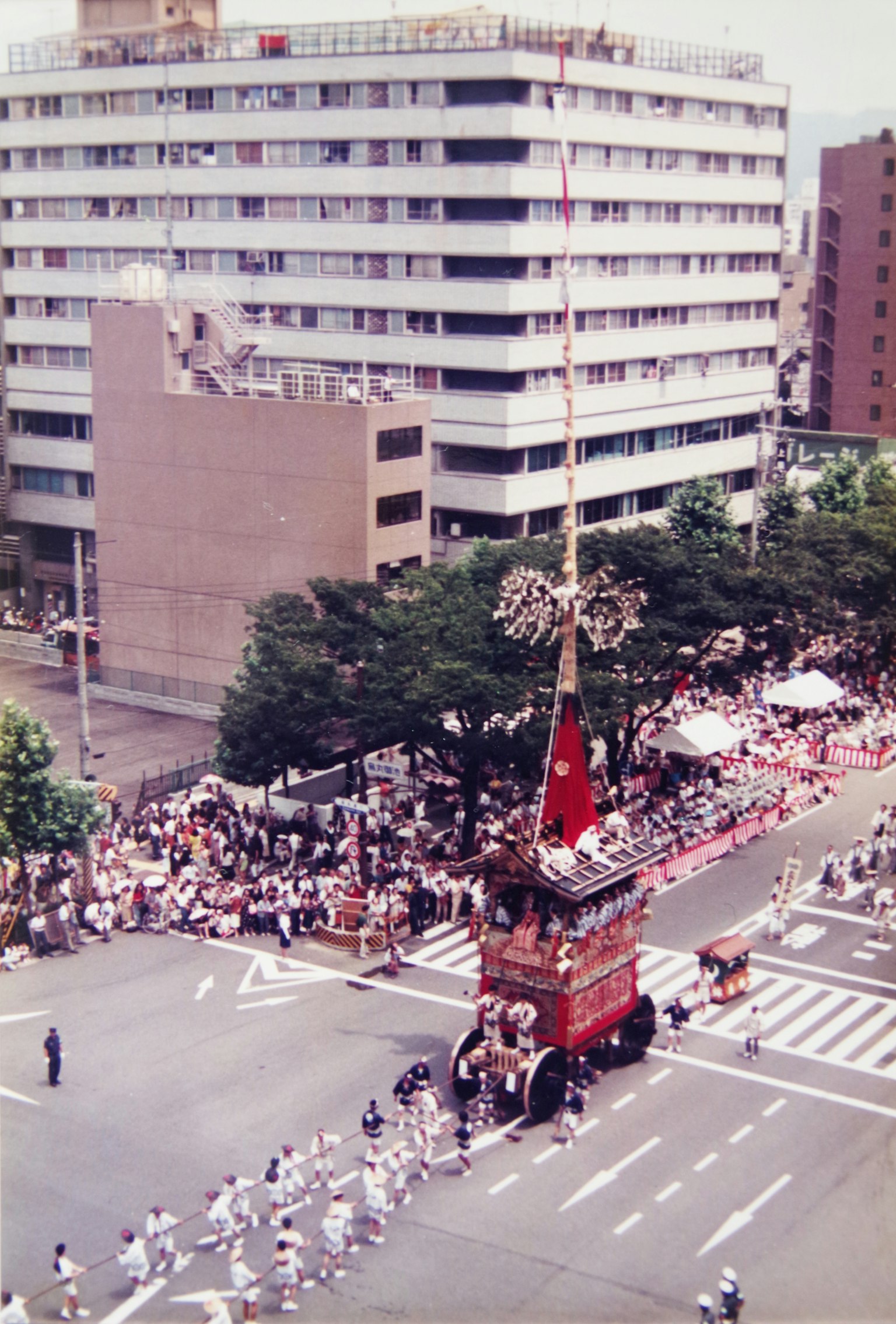 节日花车在十字路口停着，许多观众在观看