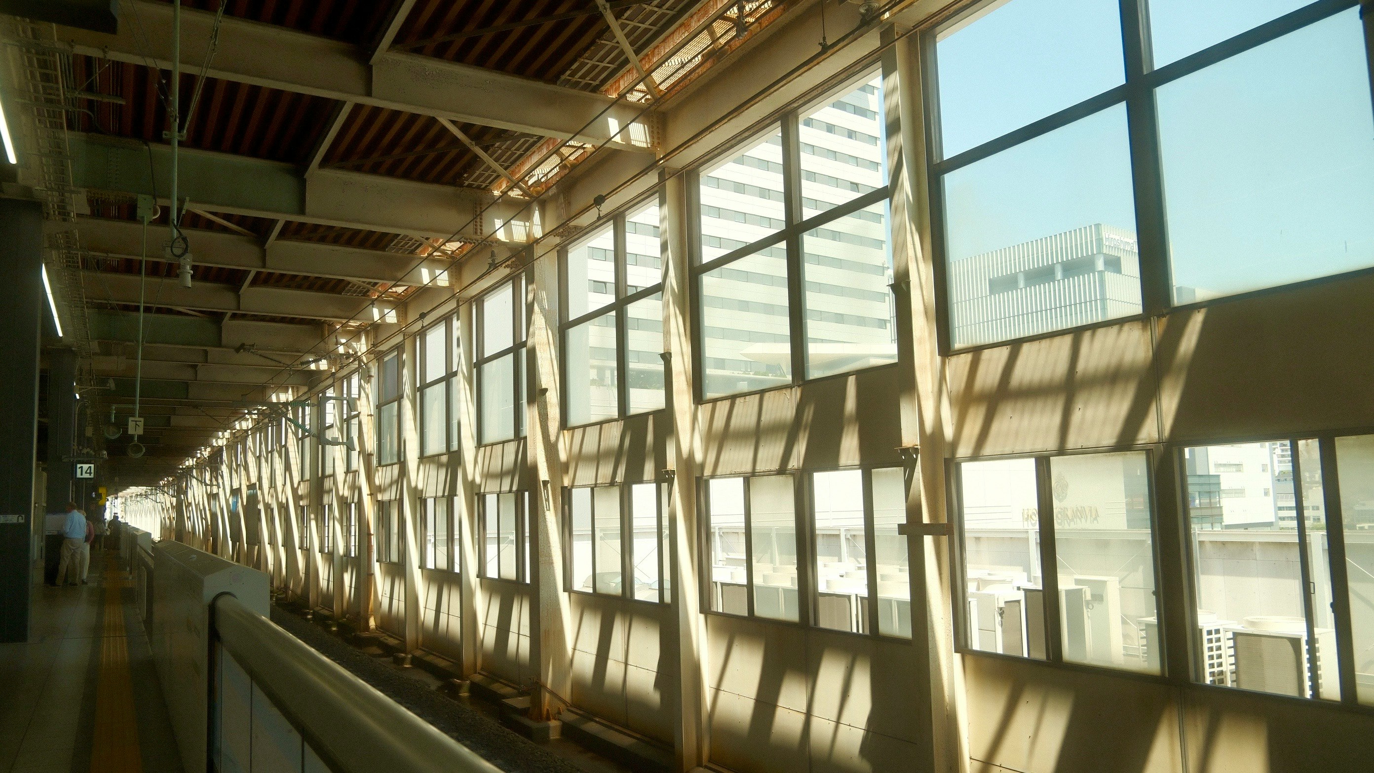 langer Bahnhofsflur mit Sonnenlicht und Schatten durch Fenster