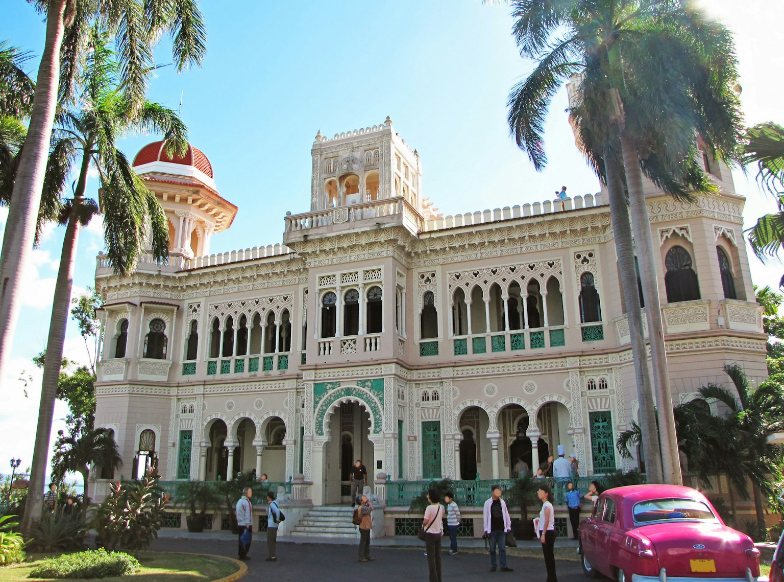 Istana bergaya kolonial yang indah dengan pohon palem dan taksi pink