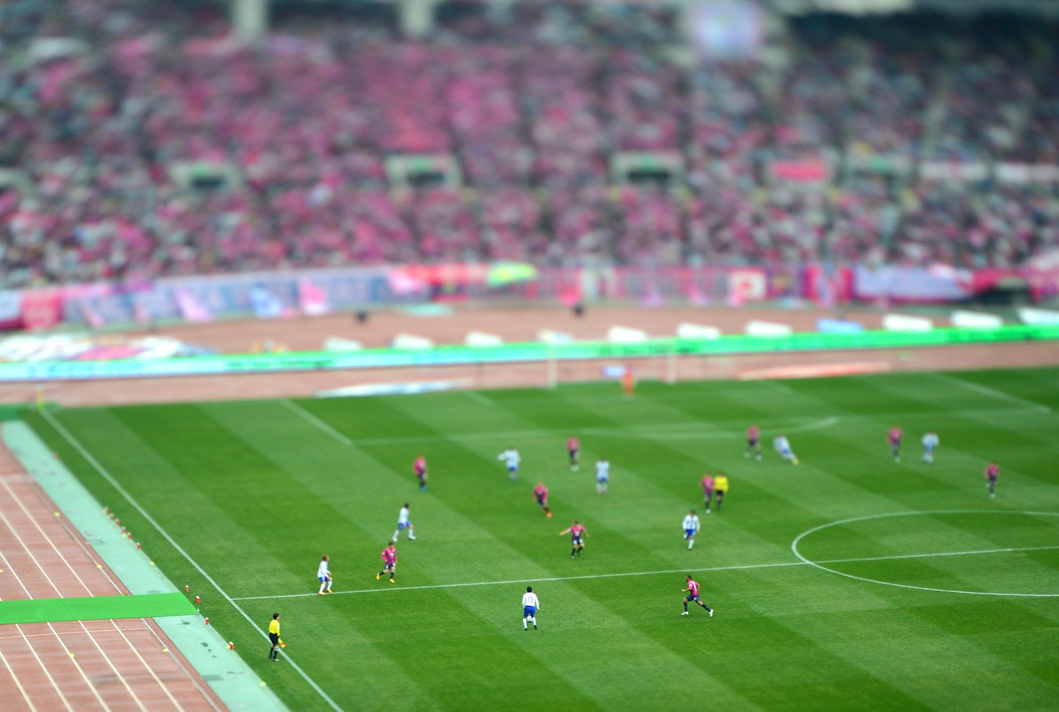 A soccer match taking place in a stadium with numerous spectators