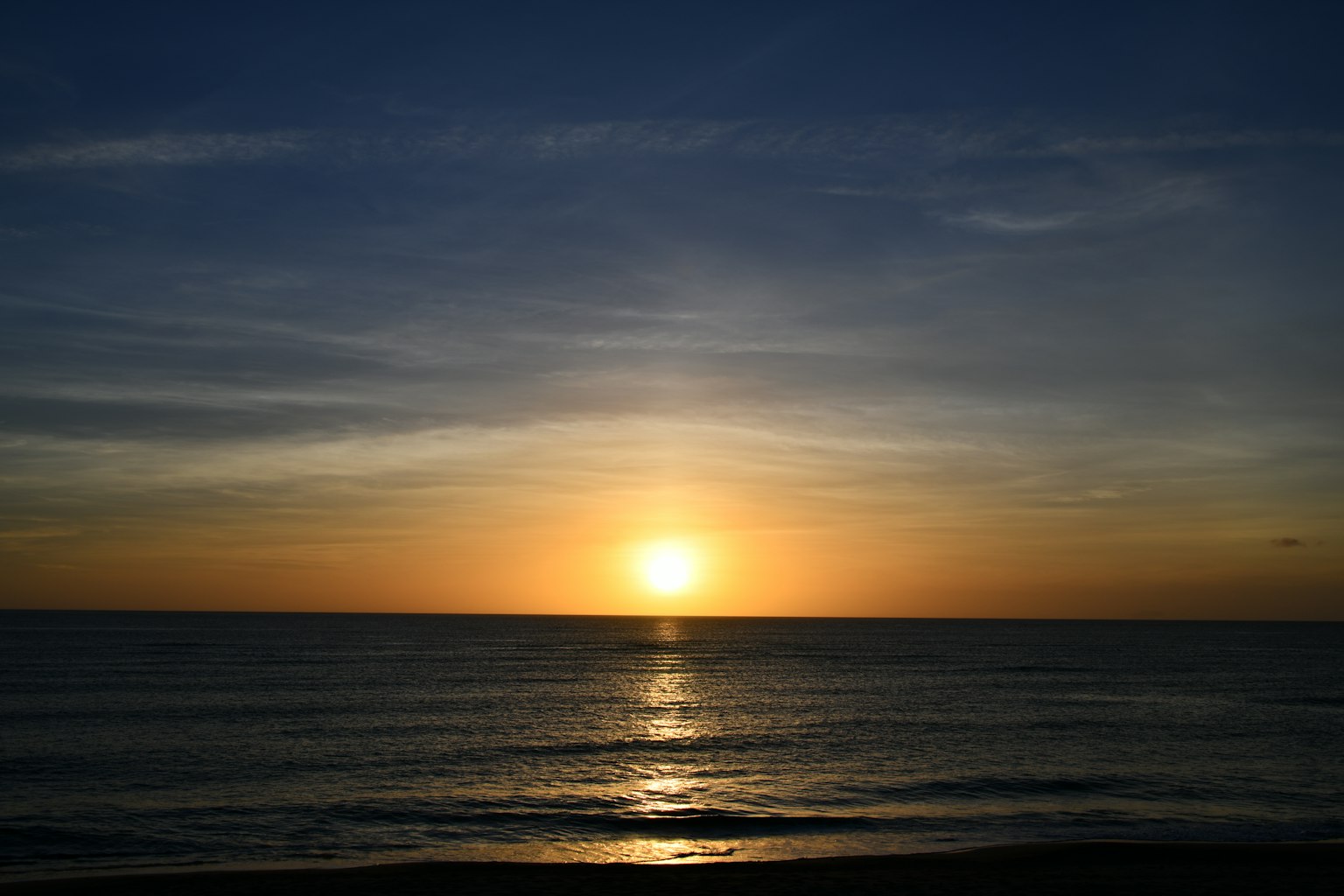 Atardecer tranquilo sobre el océano con un hermoso cielo azul