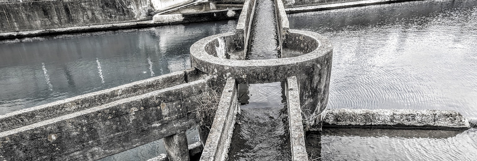Estructura circular para controlar el flujo de agua con reflejos en la superficie