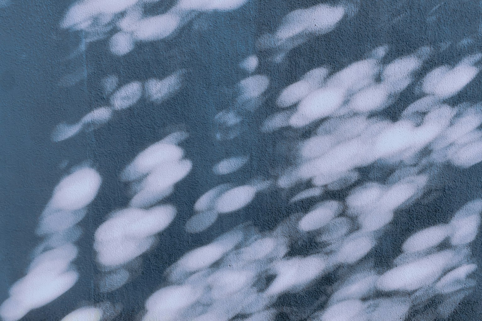 Fondo azul con patrones de nubes blancas reflejados en la superficie del agua