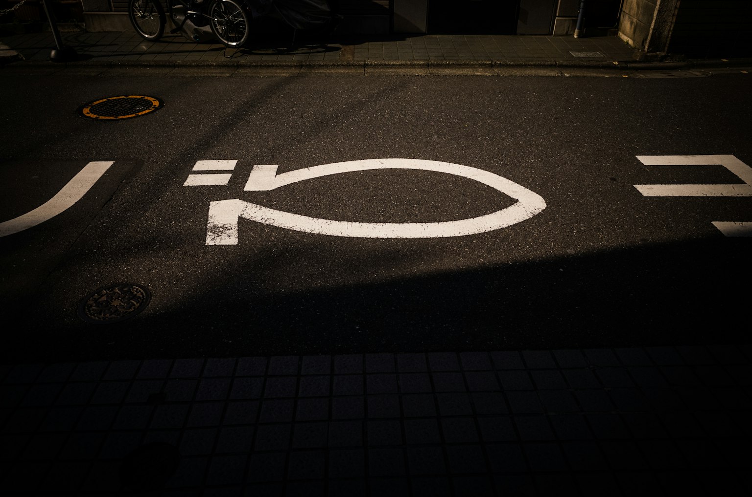 White road markings on the pavement with shadows