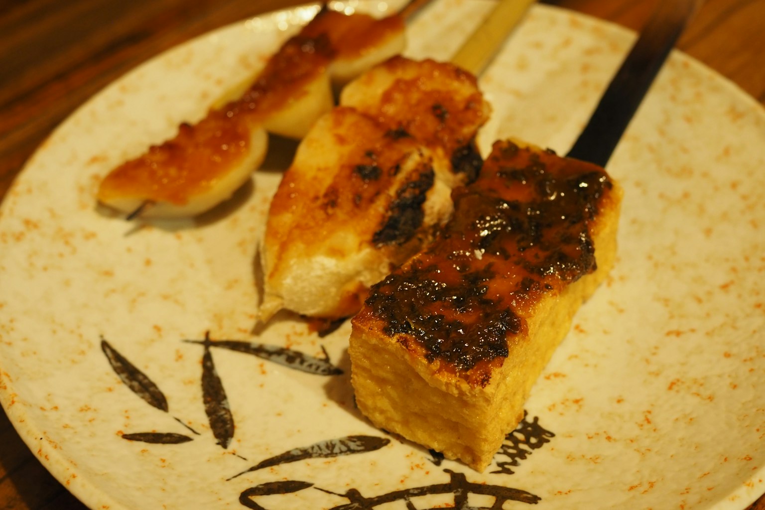 สเต๊กเต้าหู้และไก่ย่างที่มีรอยไหม้เสิร์ฟบนจานญี่ปุ่นแบบดั้งเดิม