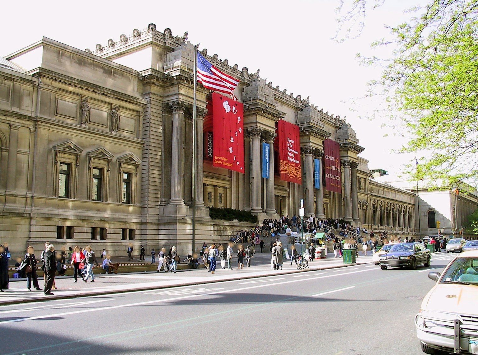 Exterior of an art museum with American flag and visitors gathering