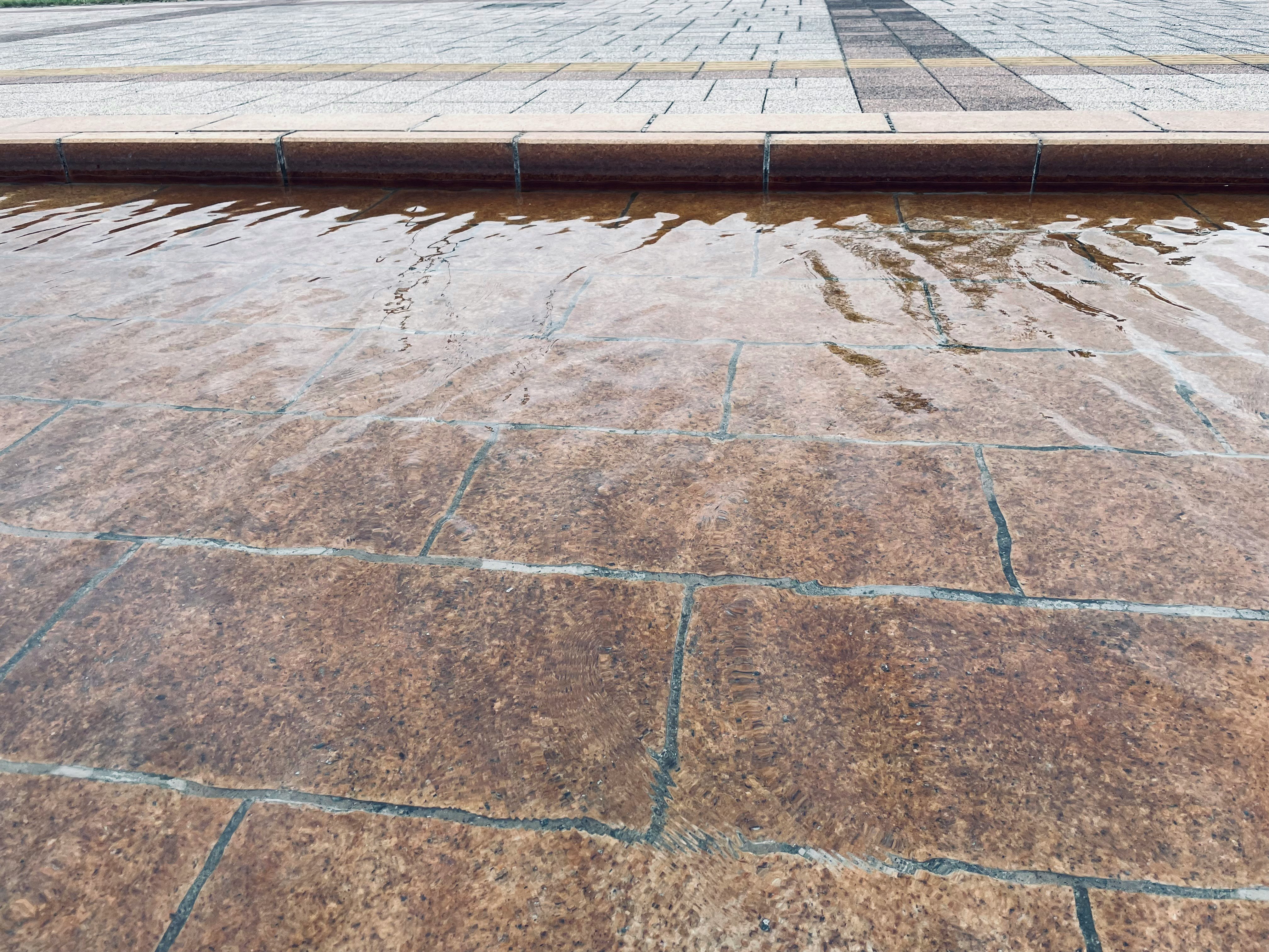 水面を静かに揺らす水路と公園の石畳