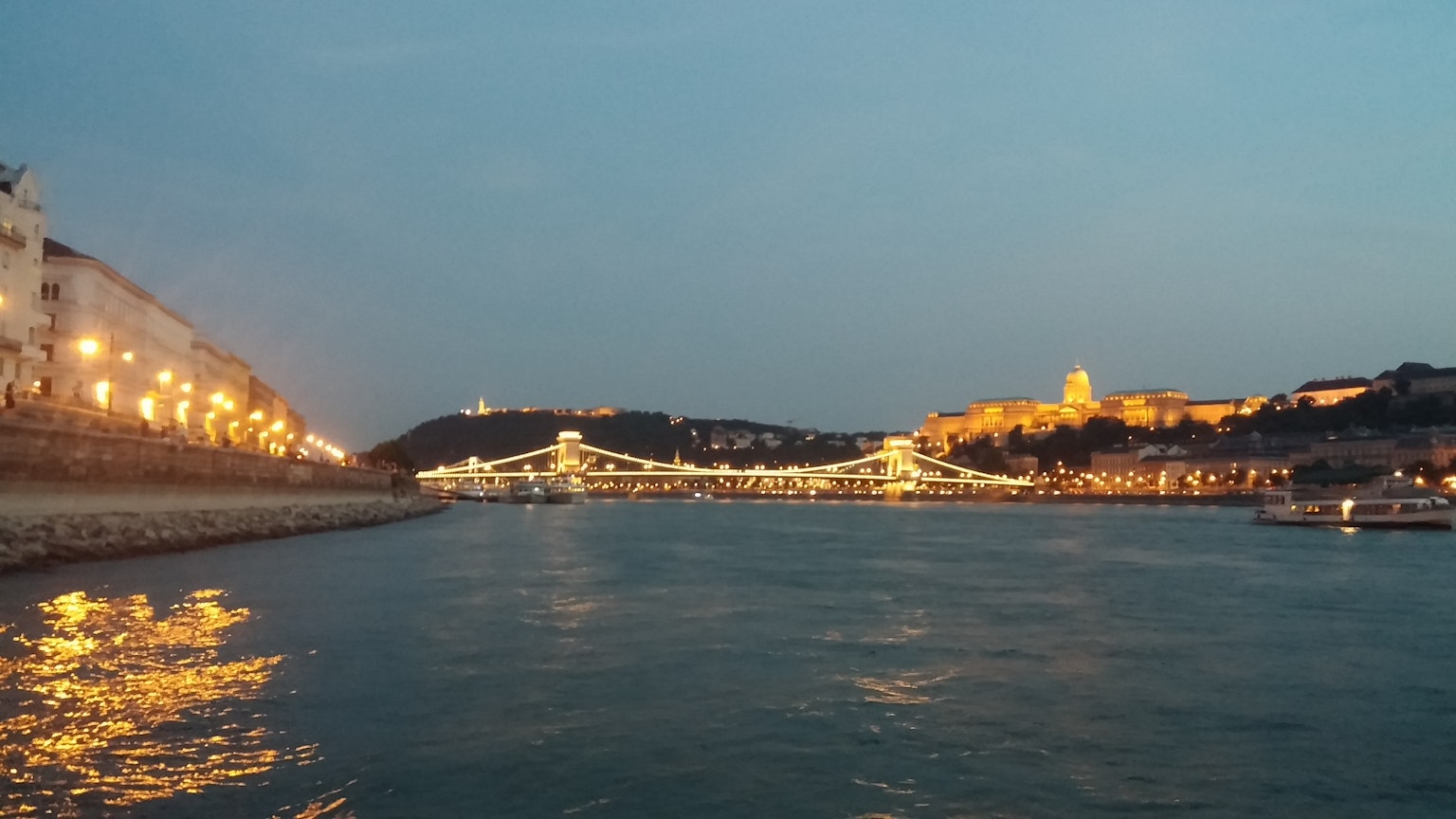 Donau in Budapest bei Dämmerung mit beleuchteten Brücken und historischen Gebäuden