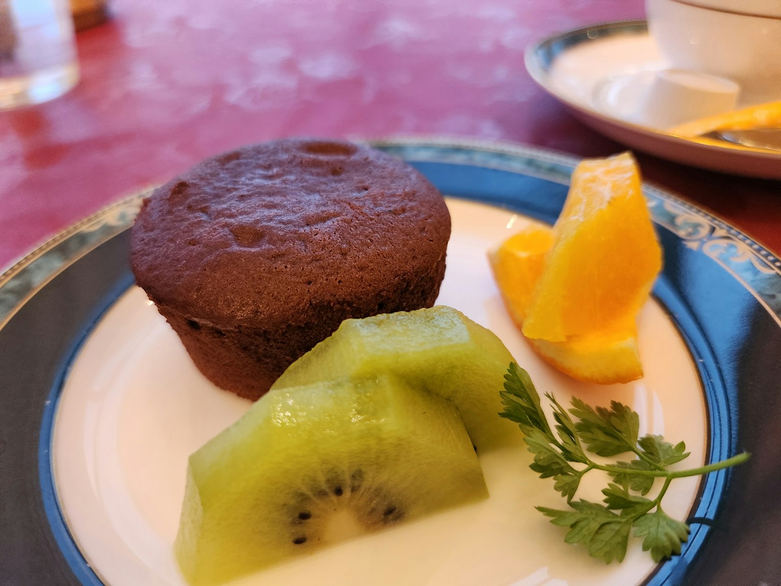 Muffin coklat disajikan dengan irisan kiwi dan jeruk